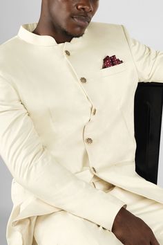 Step into elegance and style with our Merino Cream Bandhgala Premium Cotton Stretchable Blazer. This sophisticated ensemble combines traditional Indian aesthetics with contemporary fashion. Crafted from premium cotton, it offers a comfortable and breathable fit. The bandhgala, with its intricately designed mandarin collar and metallic button detailing, adds a touch of regal charm. Make a statement at any occasion with this truly unique and fashionable piece. In addition to being constructed from Designer Fitted Beige Nehru Jacket, Fitted Cream Nehru Jacket For Formal Occasions, Classic Long Sleeve Semi-formal Sets, Festive Fitted Beige Set, Classic Cream Bandhgala For Festive Occasions, Elegant Long Sleeve Cotton Suits, Festive Beige Fitted Sets, Classic Cream Nehru Jacket For Wedding, White Classic Sherwani For Formal Occasions