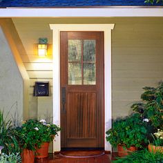 the front door of a house with potted plants