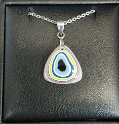 This necklace is made from semi truck fordite from Ohio. It's in a top domed triangle with a flat back. This is a nicely sized piece with great color and patterns.The bail that secures the fordite and the included 20 inch chain are stainless steel. The fordite measures about 19 mm tall. See the pictures for scale next to a nickel. Necklace holder not included. Fordite is recycled automotive paint sourced from automotive factories as well as manufacturers who paint parts for new vehicles. It forms in thin layers as car parts are painted on the racks that hold them in place. After hundreds of trips through the booth where the paint is sprayed and then baked the excess buildup is scraped off the racks. We buy this waste paint in rough chunks and recycle it into beautiful jewelry. It can take Artisan Jewelry Necklaces, Automotive Paint, Necklace Holder, Vehicle Paint, Handcrafted Artisan Jewelry, Semi Truck, Semi Trucks, Necklace Jewelry, Artisan Jewelry