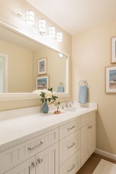 a bathroom with two sinks and pictures on the wall