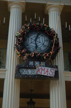 a clock on the side of a building with christmas decorations hanging from it's sides