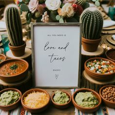 a table topped with bowls filled with food next to a sign that says love and tacos