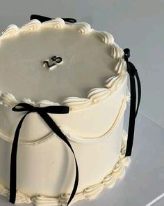 a white cake with black ribbon around it