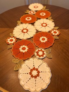 crocheted doily on a table with orange and white flowers in the center