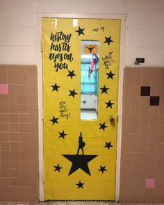 a yellow door with black stars and the words history has been given upon you on it