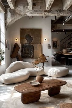 a living room filled with lots of furniture next to a painting hanging on the wall