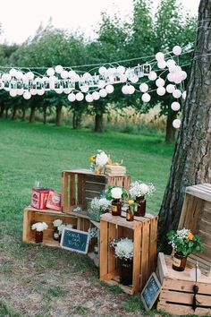 an image of a wooden crate with flowers and candles on it in front of a tree