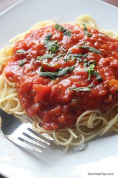 a white plate topped with spaghetti and sauce