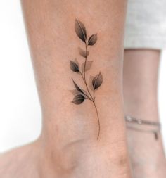 a black and white photo of a flower on the side of a woman's foot