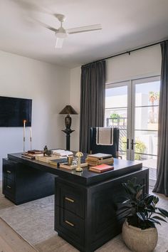 an office with a desk, chair and lamp in front of a sliding glass door