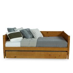 a wooden daybed with pillows and blankets on it's sides, in front of a white background