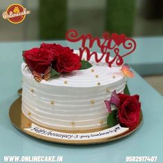 a white cake with red roses on top