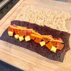 a wooden cutting board topped with food on top of a counter