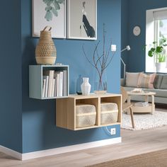 a living room with blue walls and wooden shelves on the wall next to a couch