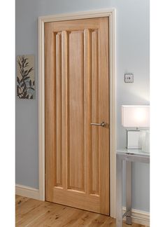 a wooden door in the corner of a room with wood flooring and blue walls