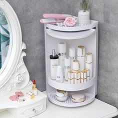 a white shelf with cosmetics and other items on it in front of a round mirror