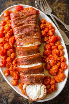 a white plate topped with bacon and tomatoes