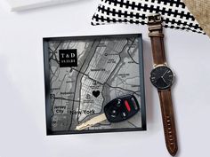 a watch sitting on top of a table next to a map and a black and white pillow