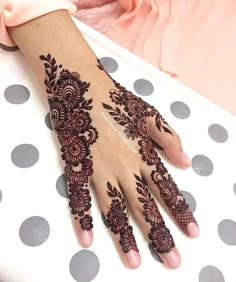 a woman's hand with henna tattoos on it