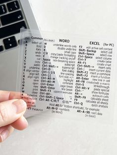 a person holding up a clear sticker with words on it next to a laptop