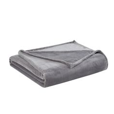 the grey blanket is folded on top of each other and ready to be used as a bed