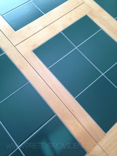 the floor is made up of green tiles and wood trimmings, along with a wooden door