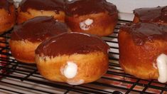 chocolate covered doughnuts cooling on a wire rack