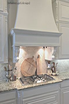 a stove top oven sitting inside of a kitchen next to white cabinets and counter tops