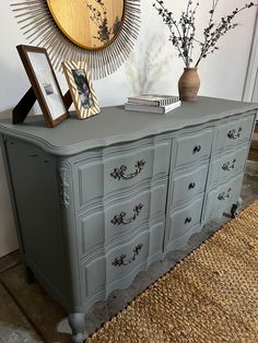 an antique dresser painted gray with gold accents