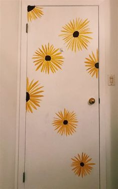 the door is painted with yellow and black sunbursts on white paper,