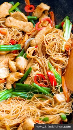 stir fried noodles with chicken and vegetables in a wok