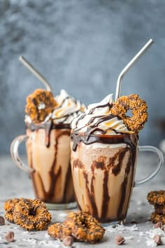 two mugs filled with ice cream and chocolate covered pretzel cookies on top