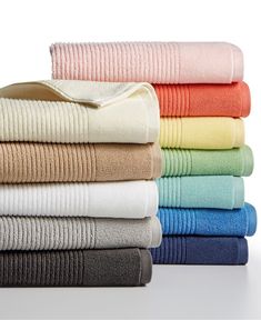 towels stacked on top of each other in different colors and sizes, all folded up