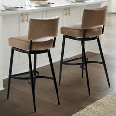 two brown stools sitting in front of a kitchen island