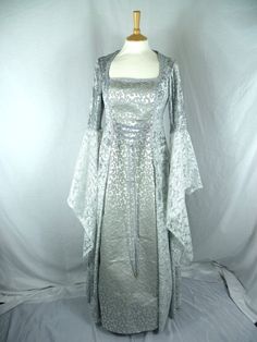 THIS DRESS IS READY MADE.  It has been made from beautiful sliver velvet and silver and grey bridal brocade.The sleeves are part velvet with stunning Pale grey and silver embriodered lace. It has a corset style front and back with lacing so you can adjusted the   dress to fit your body shape  It will fit from. BUST : 40" to 42"   ( 102 cm to 107 cm) WAIST : 38" to 40" ( 97 cm to 102 cm ) HIPS : 44" to 46" ( 112 cm to 117 cm ) LENGTH IS APPROX : 59"/ 150 cm  Arm circumstance 16 " / 41 cm Combined Silver Medieval Dress, Medieval Wedding Dress, Medieval Wedding, Fantasy Gowns, Medieval Dress, Corset Style, Ready Made, Body Shape, Body Shapes