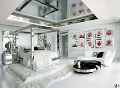 a bedroom with white furniture and pictures on the wall