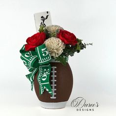 a football vase with roses and carnations in it