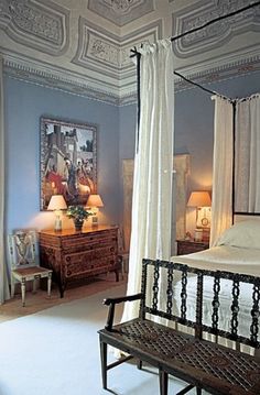 a canopy bed sitting in the middle of a bedroom