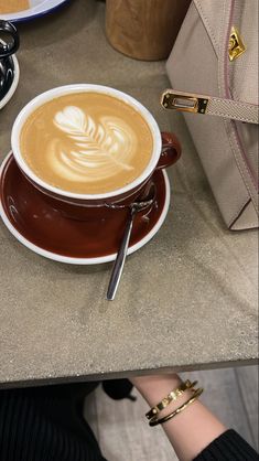 a cappuccino is served in a brown and white cup on a saucer