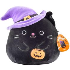 a black cat with a purple hat on it's head and a pumpkin in its mouth