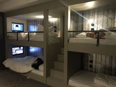 three bunk beds in a room with lights on