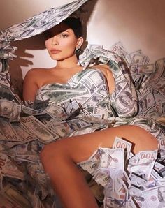 a woman sitting on top of a pile of money wearing a white dress and hat