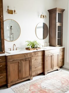 a bathroom with two sinks and wooden cabinets