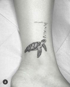 a small turtle tattoo on the ankle with bubbles coming out of its mouth and tail