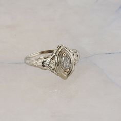 Antique 18K White Gold Marquise Diamond Art Deco Ring, pierced designs floral engraved, 5 x 2.5mm center marquise diamond, FVS, .5 inch across, Ring size 7.5, Circa 1930, 2.2 grams Stock # BB331R13 Most rings are sizable for a small fee. If the ring you are considering is the incorrect size contact us for a quote. This listing contains photographs of the actual item you will receive.  Our items are in excellent condition with little or no signs of wear and many are one of a kind pre-owned estate finds.   Please look closely at the pictures in this listing as they are part of the product description. Please read the description, as any imperfections or condition comments will be included.  We do our best to accurately describe the condition of each piece and encourage you to ask questions p Antique Engagement Rings Silver, Silver Art Deco Ring, Antique Engagement Rings Victorian, Diamond Art Deco Ring, Wedding Rings Art, Victorian Engagement Rings, Vintage Art Deco Rings, Ivory Gown