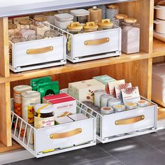 an organized kitchen cabinet with drawers and food items in the bins on the bottom shelf