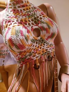 a mannequin wearing a multicolored crocheted shawl with fringes