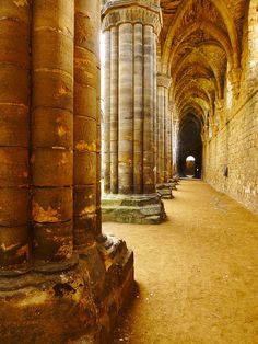 the inside of an old building with columns and arches on either side is dirt flooring