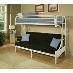 a futon bunk bed with blue pillows in a living room next to a window