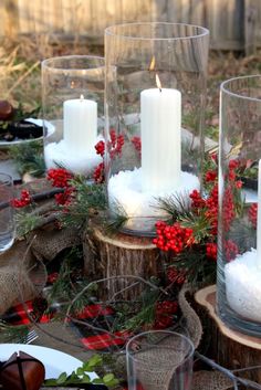 a table topped with lots of candles and christmas wreaths on top of wooden slices